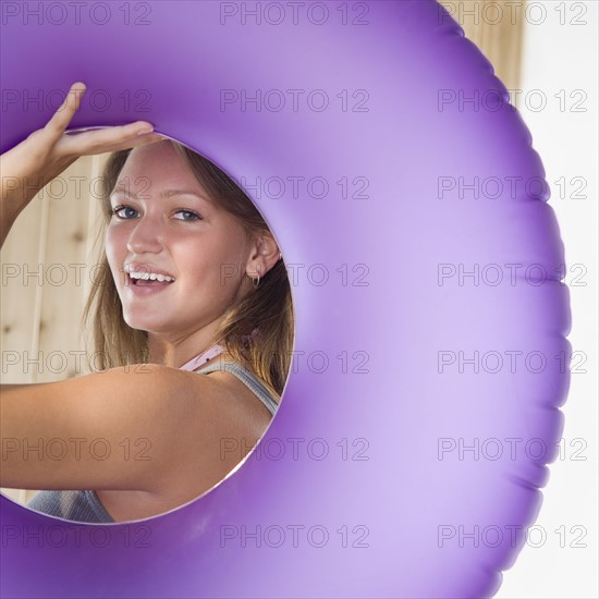 Young woman smiling through middle of inner tube. Date : 2006