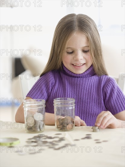 Girl counting and sorting change. Date : 2006
