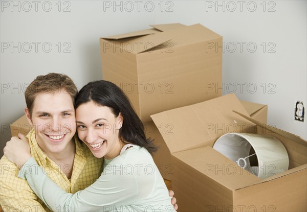 Couple hugging next to boxes in new house. Date : 2006