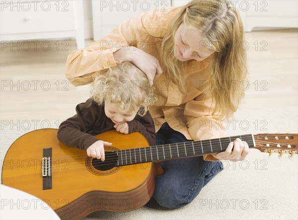 Mother and child playing with guitar. Date : 2006