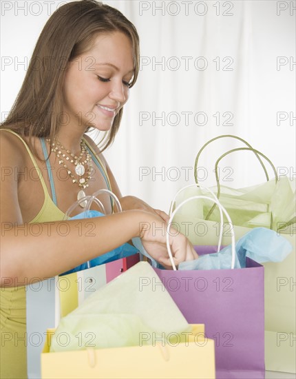 Woman smiling and looking in shopping bags. Date : 2006