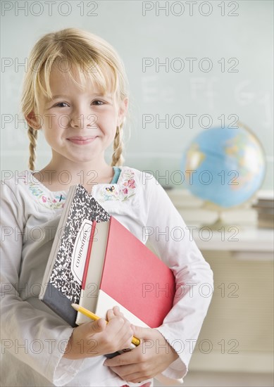 Young girl holding school books and smiling. Date : 2006