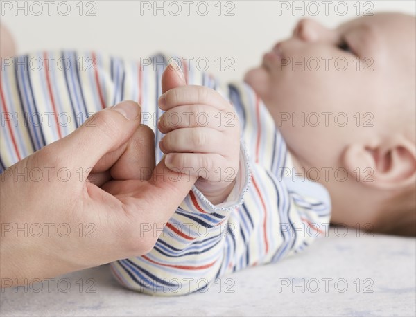 Close up of baby holding mother’s hand. Date : 2006