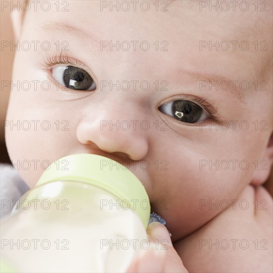 Close up of baby drinking from bottle. Date : 2006