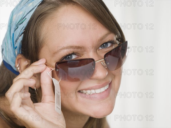 Young woman smiling and trying on sunglasses. Date : 2006