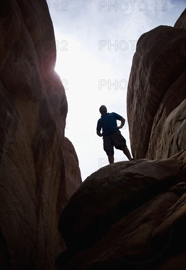 Man atop Red Rock Arches National Park Moab Utah USA. Date : 2006