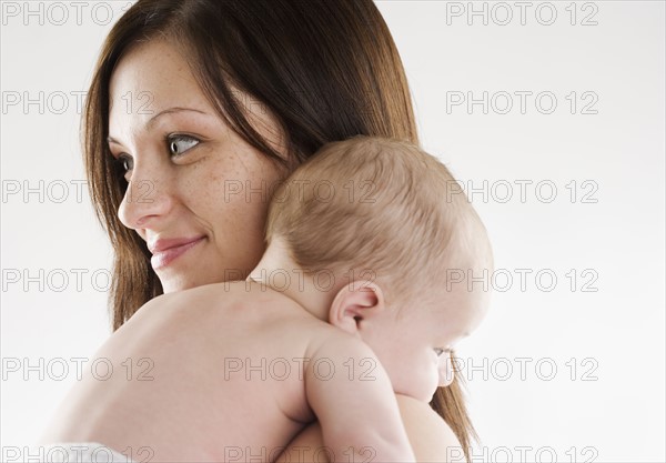 Mother holding baby on her shoulder. Date : 2006