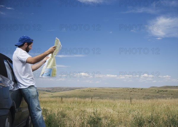 Man reading a map outdoors. Date : 2006