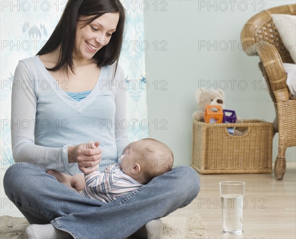 Mother holding baby on her lap. Date : 2006