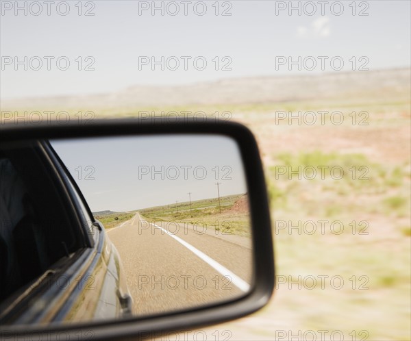 Road reflected in car side mirror. Date : 2006