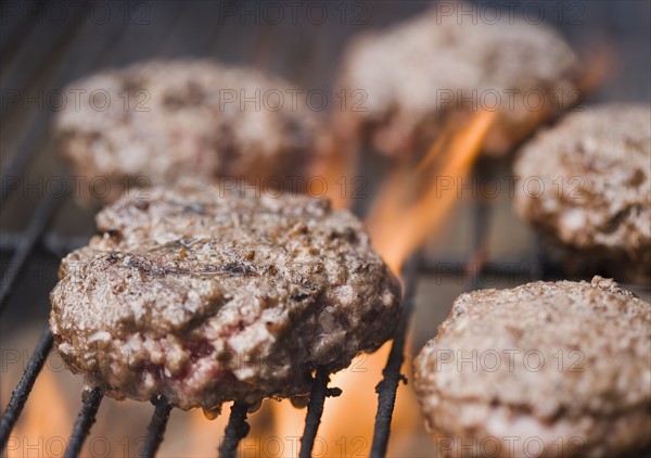 Hamburger patties cooking on grill. Date : 2006