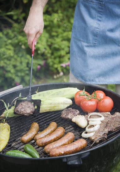 Grilling food outdoors in summer. Date : 2006