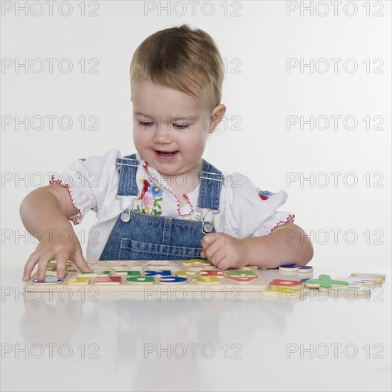 Female toddler playing with a puzzle. Date : 2006