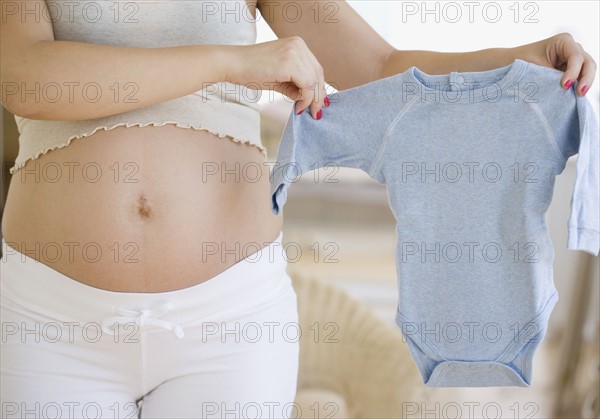 Pregnant woman holding baby clothes. Date : 2007