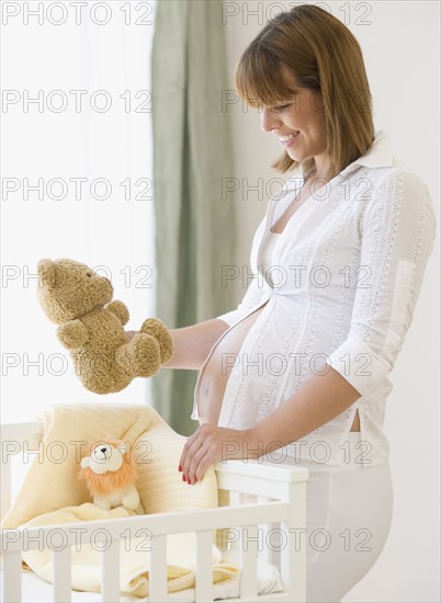 Pregnant woman smiling at teddy bear. Date : 2007