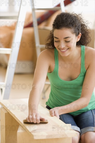 Woman sanding piece of wood. Date : 2007