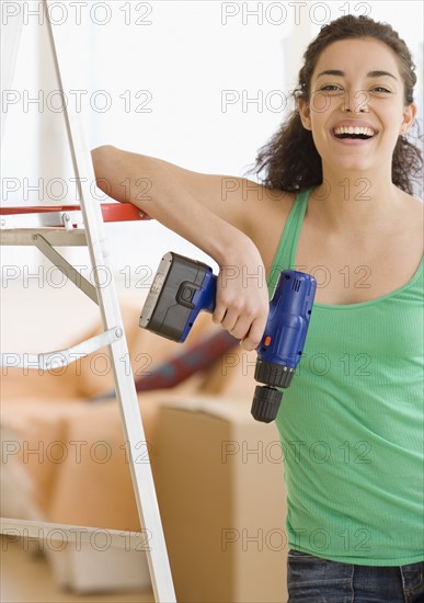 Woman holding cordless drill. Date : 2007