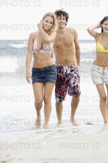 Friends walking in ocean surf. Date : 2007