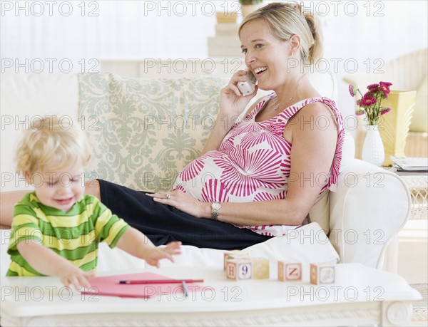 Pregnant mother talking on telephone. Date : 2007