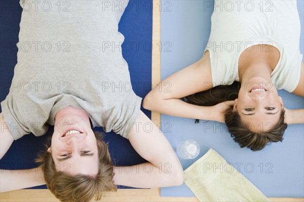 Couple laying on yoga mats. Date : 2007