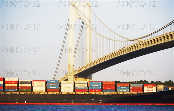 Container barge under Verrazano Narrows Bridge, New York City. Date : 2007