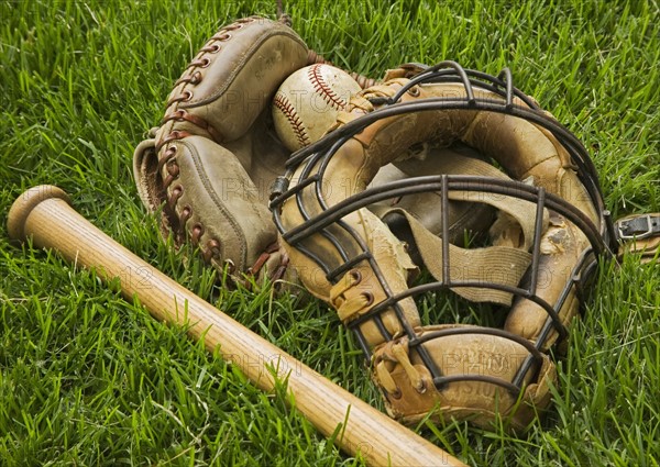 Old fashioned baseball equipment in grass. Date : 2006