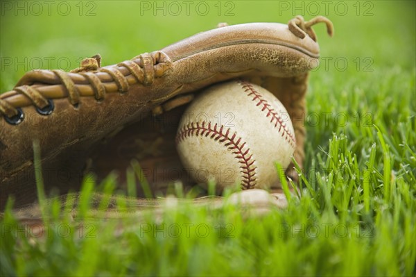 Baseball and mitt laying on grass. Date : 2006