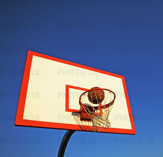 Basketball in mid air over hoop. Date : 2007