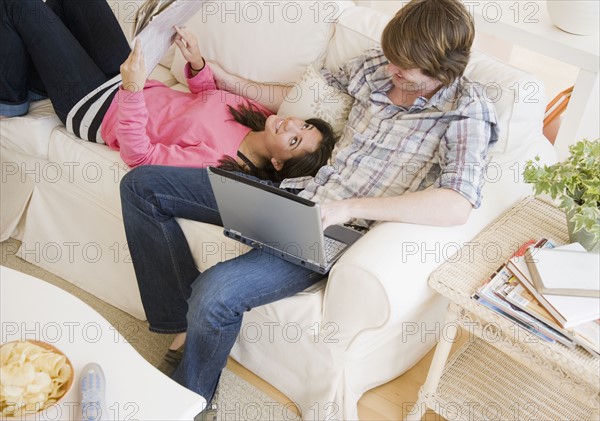 Couple relaxing on sofa. Date : 2007