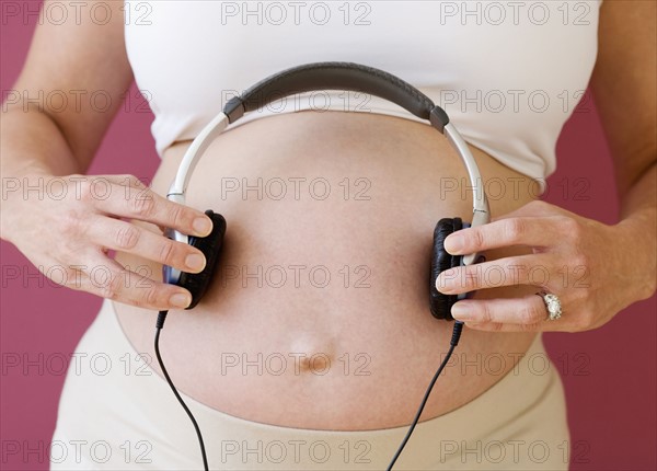 Pregnant woman holding headphones on belly. Date : 2007