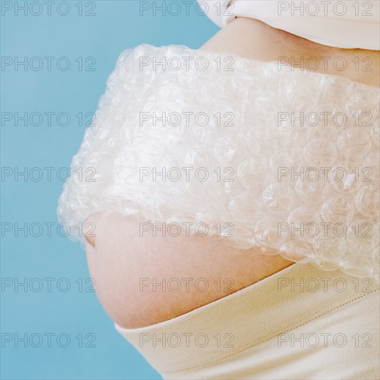 Pregnant woman’s belly wrapped in bubble wrap. Date : 2007