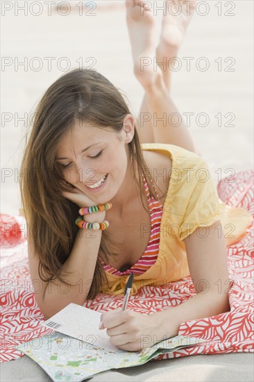 Women writing letter at beach. Date : 2007