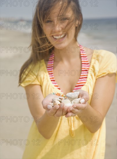 Woman holding handful of shells. Date : 2007