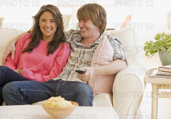 Couple laughing on sofa. Date : 2007