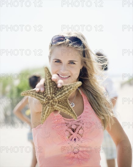 Woman holding up starfish. Date : 2007