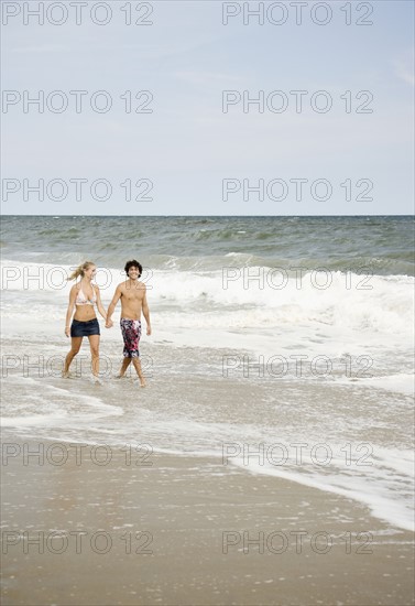 Couple walking in ocean surf. Date : 2007