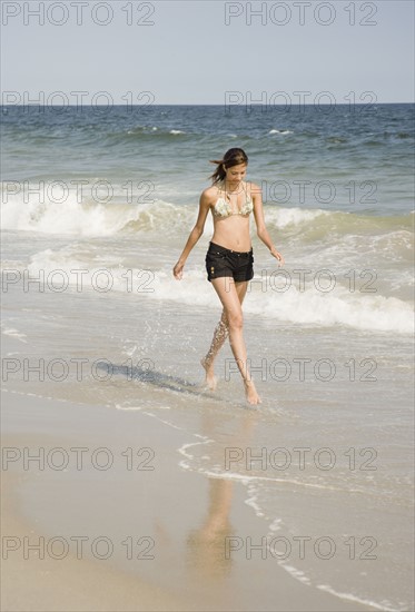 Young woman walking in ocean surf. Date : 2007