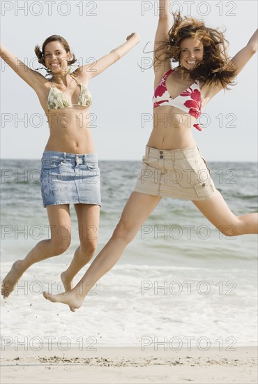 Young women jumping at beach. Date : 2007