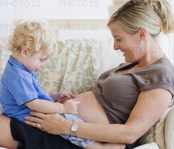 Baby touching mother’s pregnant belly. Date : 2007