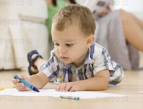 Baby coloring on floor. Date : 2007