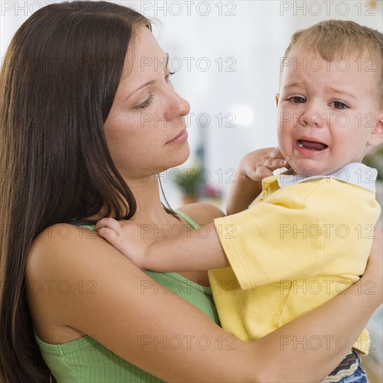 Mother holding crying baby. Date : 2007