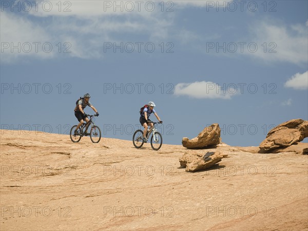 Couple riding mountain bikes in desert. Date : 2007