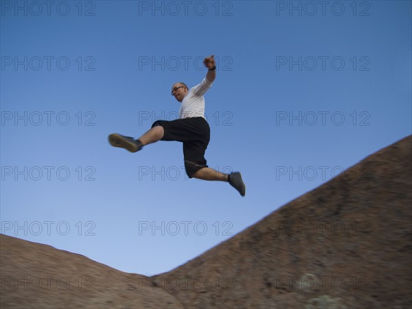 Man jumping over rock formations. Date : 2007