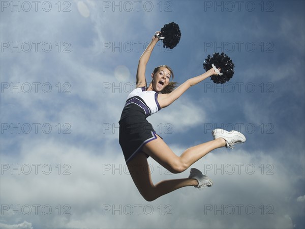 Cheerleader with pom poms jumping. Date : 2007