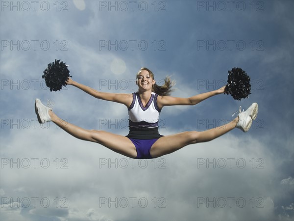 Cheerleader with pom poms jumping. Date : 2007