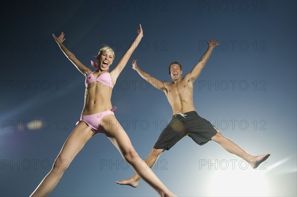 Couple in bathing suits jumping. Date : 2007