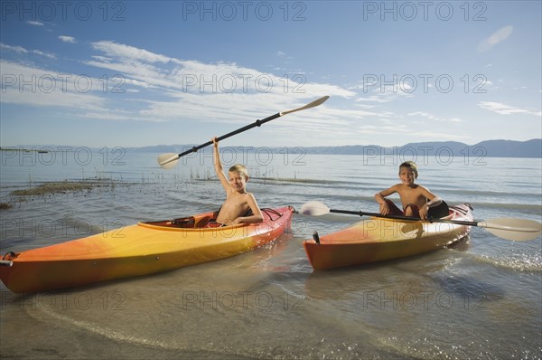 Brothers paddling in canoes on lake, Utah, United States. Date : 2007