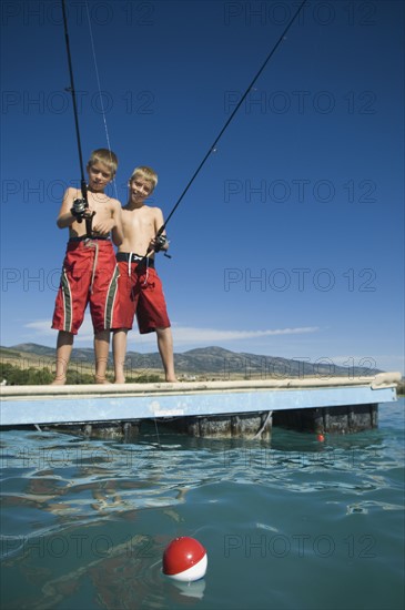 Brothers fishing off dock in lake, Utah, United States. Date : 2007