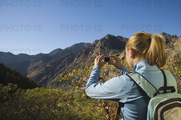 Woman taking photograph of valley, Utah, United States. Date : 2007