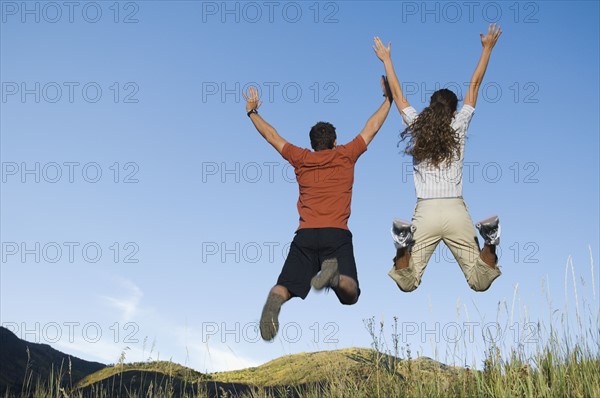 Rear view of couple jumping, Utah, United States. Date : 2007